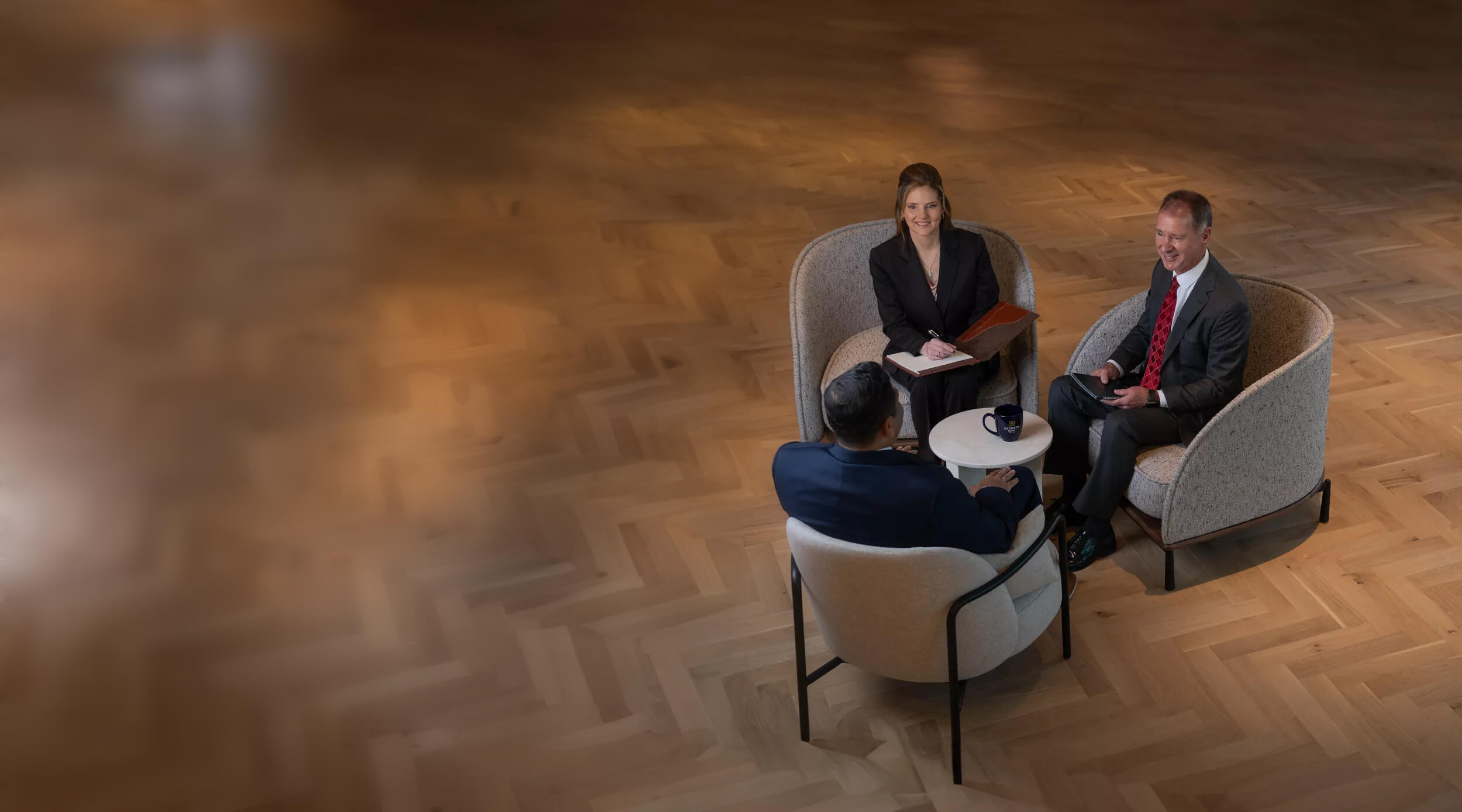 Bankers sitting at a small coffee table.